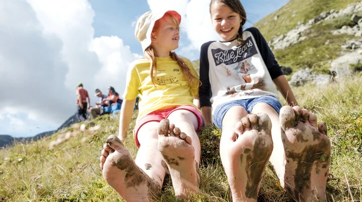 Wandern in den Chiemgauer Alpen | © DAV/Hans Herbig Mit Kindern in den Brgen: Zwei Mädchen mit nackten Füßen auf einer Wiese | © DAV/Hans Herbig